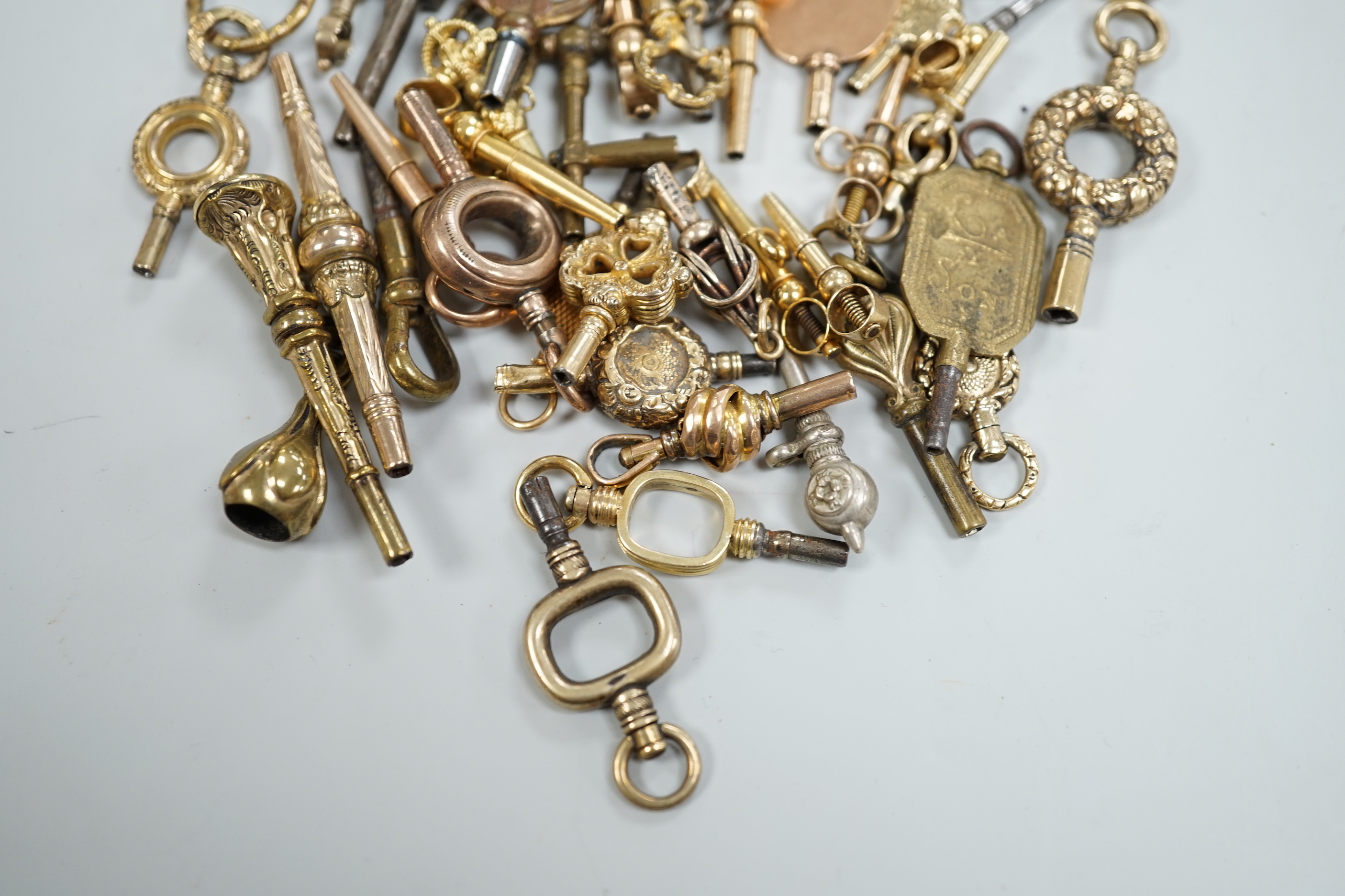 Forty assorted mainly 19th century yellow metal, yellow metal overlaid and base metal small watch keys, including trade insignia and keys for turning in one direction, largest 52mm, together with a limited edition copy,